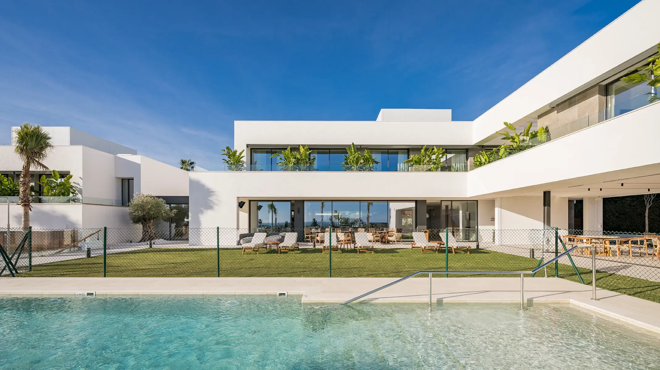 Naghoi recovery sanctuary exterior — swimming pool, gardens and modern white architecture in Estepona, Spain.